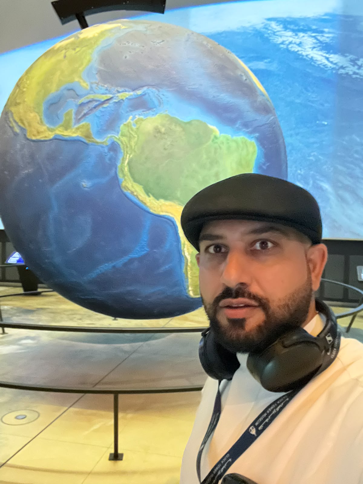 Mohsin Tutla in front of a large model of the Earth