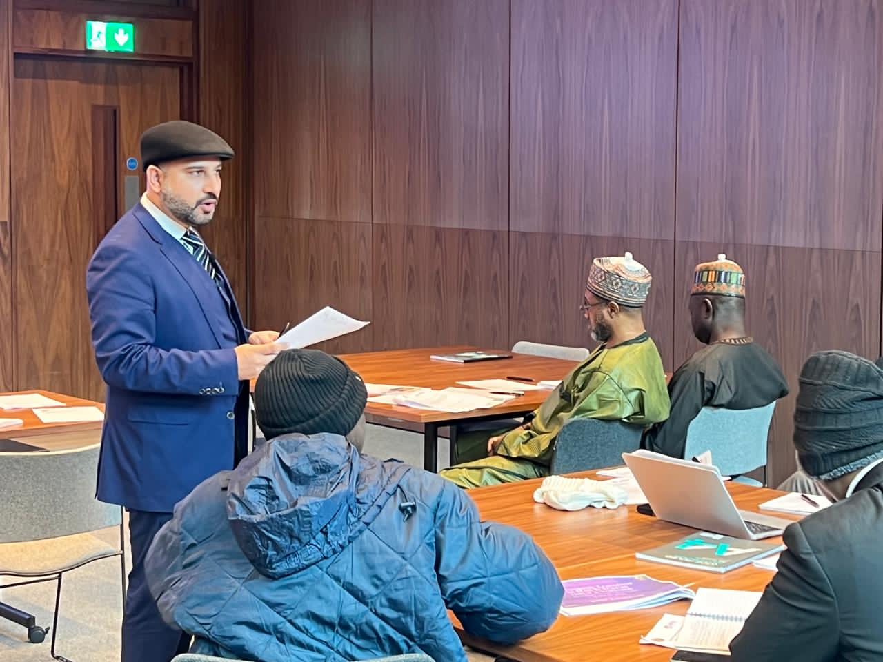 Mohsin Tutla briefing Nigerian delegates around a table