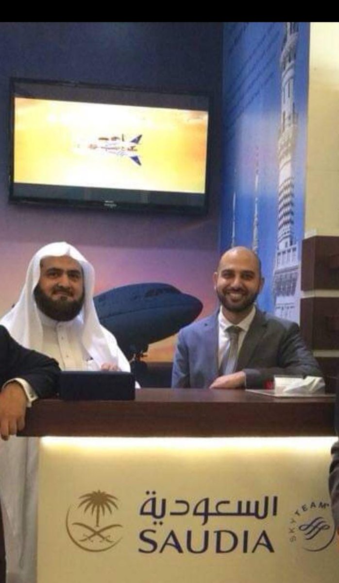 Mohsin Tutla seated beside a Saudi sheikh at the Saudia airline desk at an exhibition